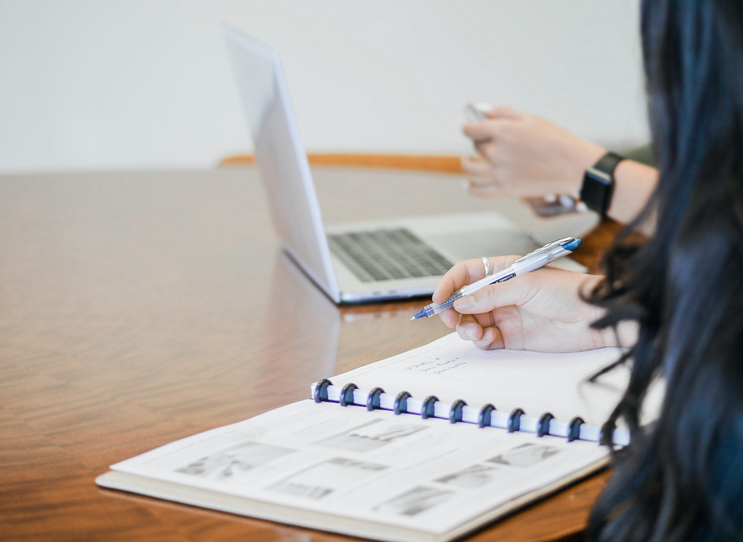 Two people sat at desk writing report